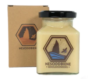 ノルウェーの森で採れたハチミツの瓶は、装飾的な四角い容器に入れられ、安全な輸送のために環境に優しい段ボールでしっかりと梱包されています。