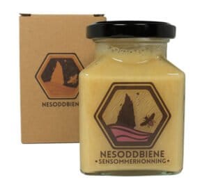 ノルウェーフィヨルド産レイトサマーハニーの瓶は、装飾的な四角い容器に入れられ、安全な輸送のために環境に優しい段ボールでしっかりと梱包されています。