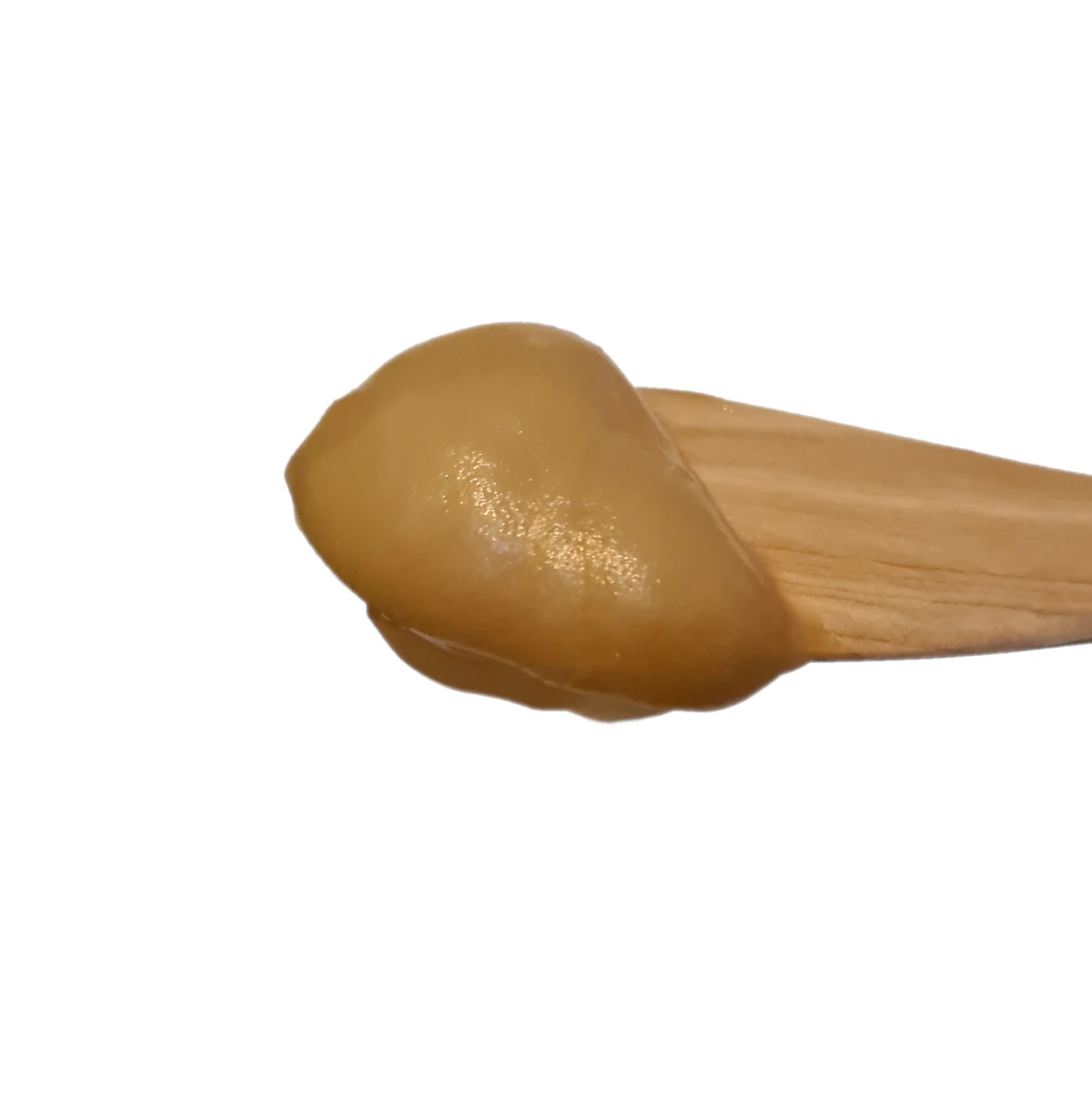 A smooth scoop of creamy, raw Norwegian honey on a wooden butter knife, showcasing its silky texture.